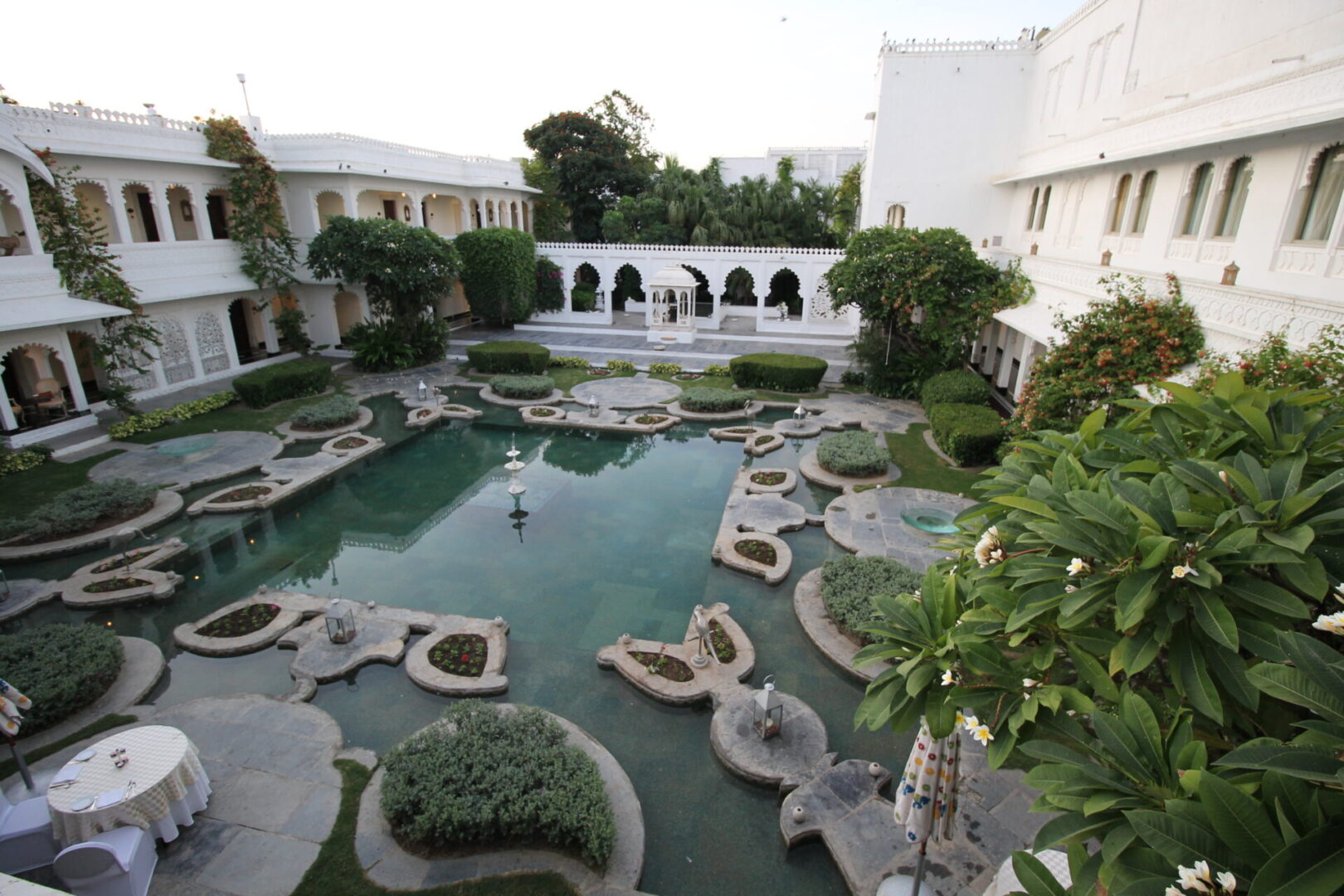 A pool with plants and trees in it